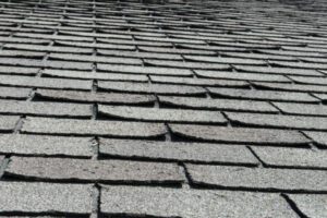 Cracked roof shingles in Aurora ON A Close-Up of Cracked Gray Shingles on a Roof in Aurora, Ontario